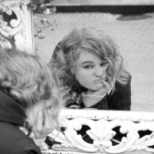 Молодая блондинка смотрит в зеркало, мы видим отражение